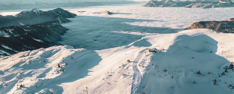 Vue drône sur le domaine skiable, au-dessus de la mer de nuage.