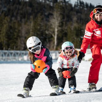 Monitrice de ski avec deux jeunes enfants