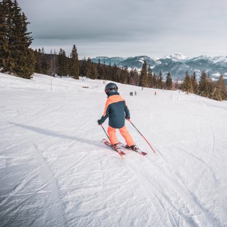 Enfant skiant de dos avec le paysage des Aillons-Margériaz